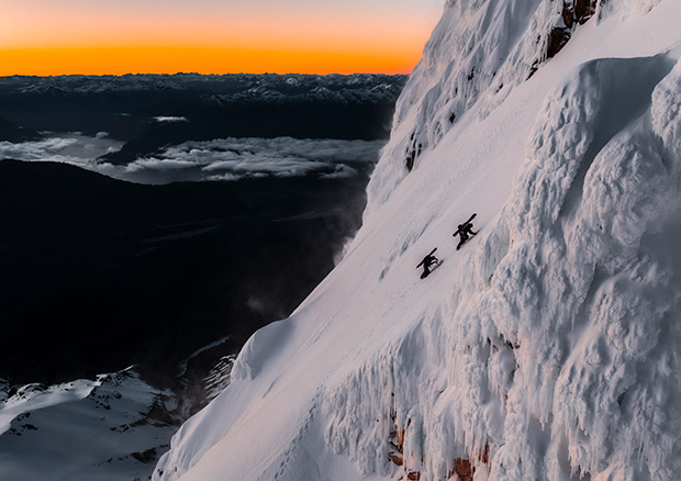 Paysage de montagne, deux skieurs qui montent la pente, skis sur le dos