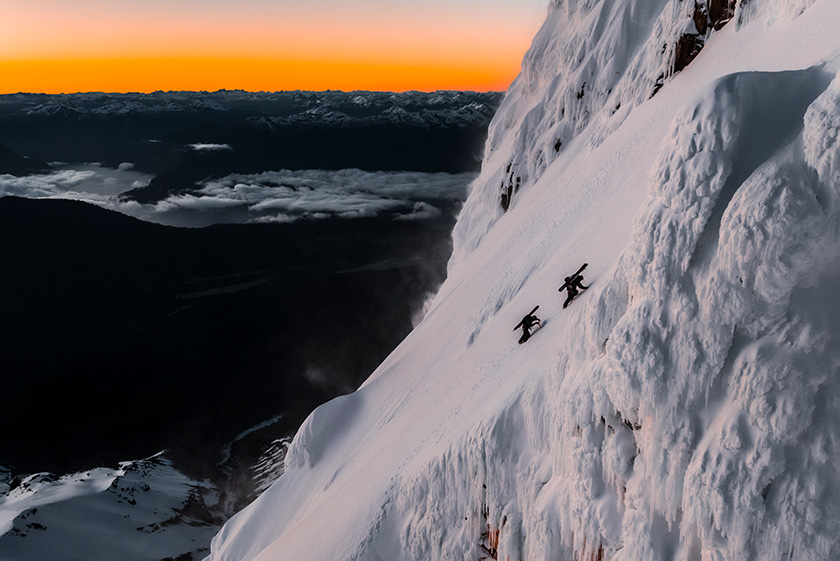 Paysage de montagne, deux skieurs qui montent la pente, skis sur le dos