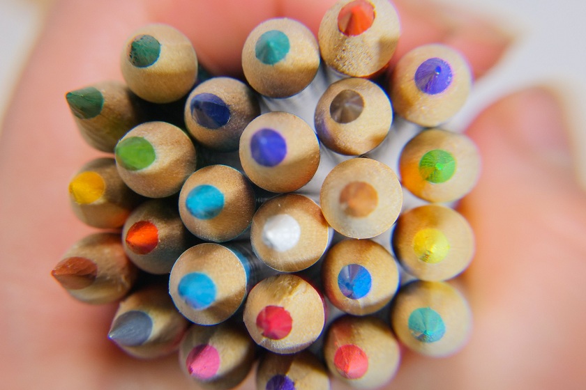 Une main tenant des crayons de couleur
