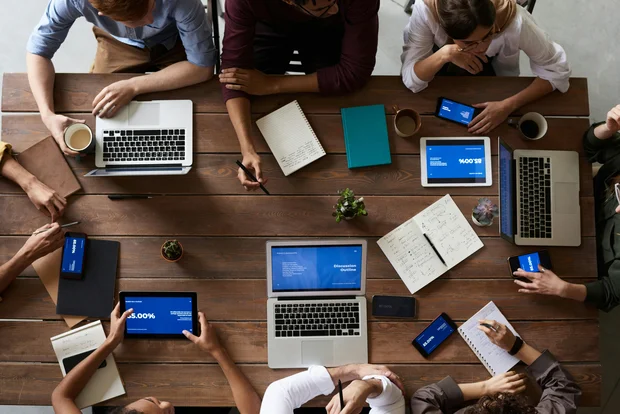 photo de personnes en réunion avec des outils numériques