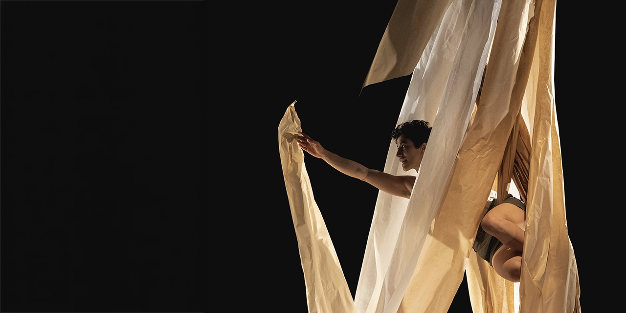 Une circassienne s'enroule et s'acroche dans des bandes de papier