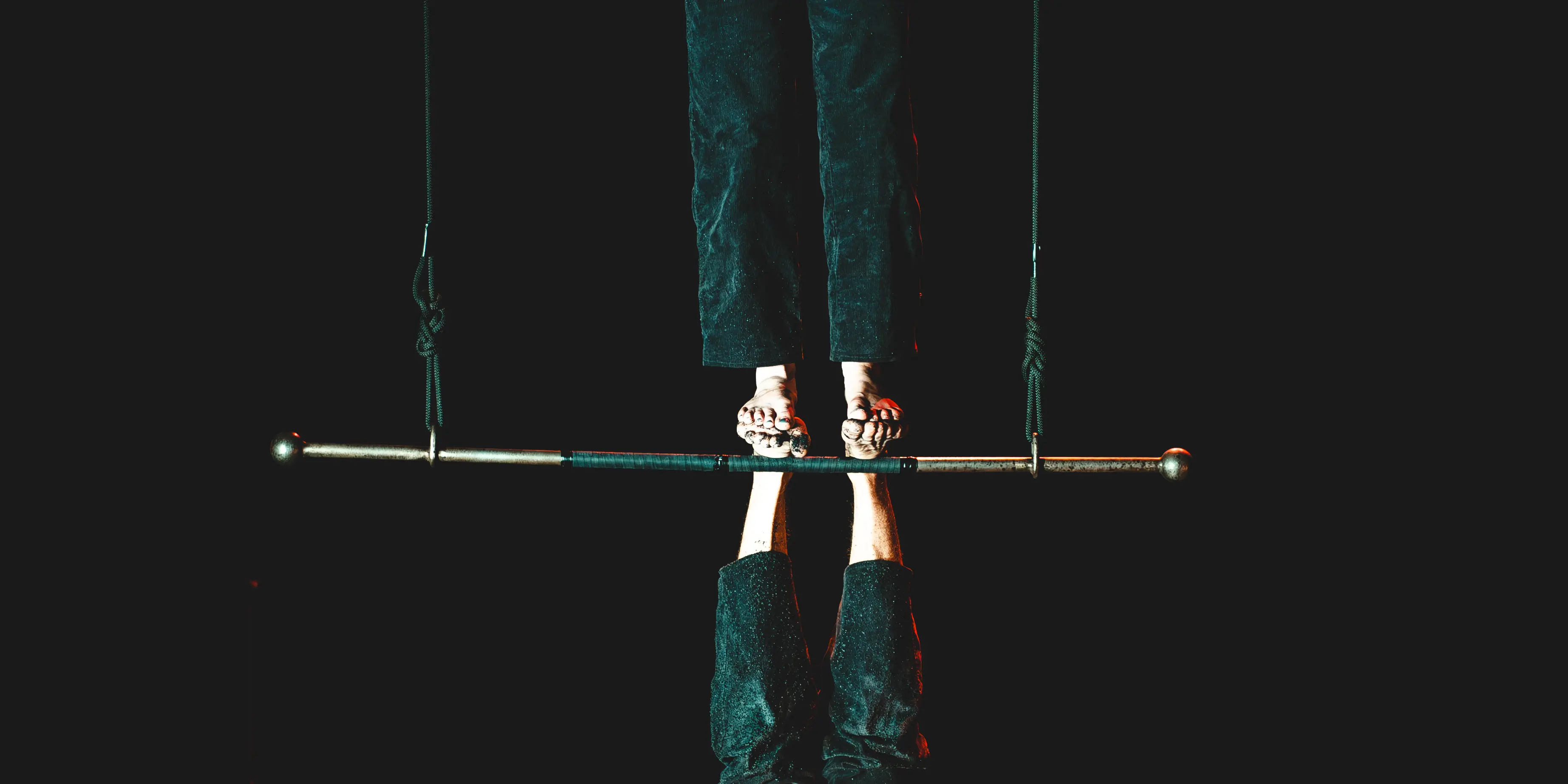 Les pieds des deux circassiens se touchent sur le trapèze, l'un dans le sens de la gravité et l'autre non.