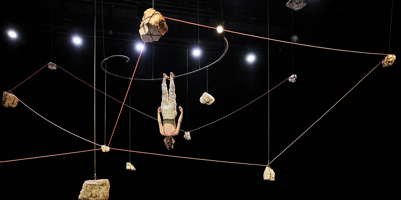 La circassienne Nina Harper est suspendue la tête en bas dans une constellation de pierres.