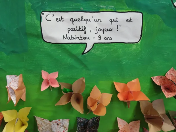 "C'est quelqu'un qui est positif, joyeux !" Nabintou, 9 ans. Une fresque représentant un jardin coloré et des mots d'enfants sur le thème de la tolérance.