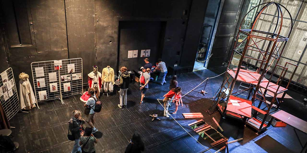Un groupe de personnes se trouve sur le plateau du Grand Théâtre et admire la structure d'un décor de spectacle