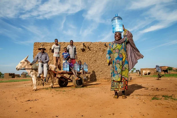 Portrait d'une famille avec des bouteilles d'eau à Bara Bangou, région de Tillabéri.