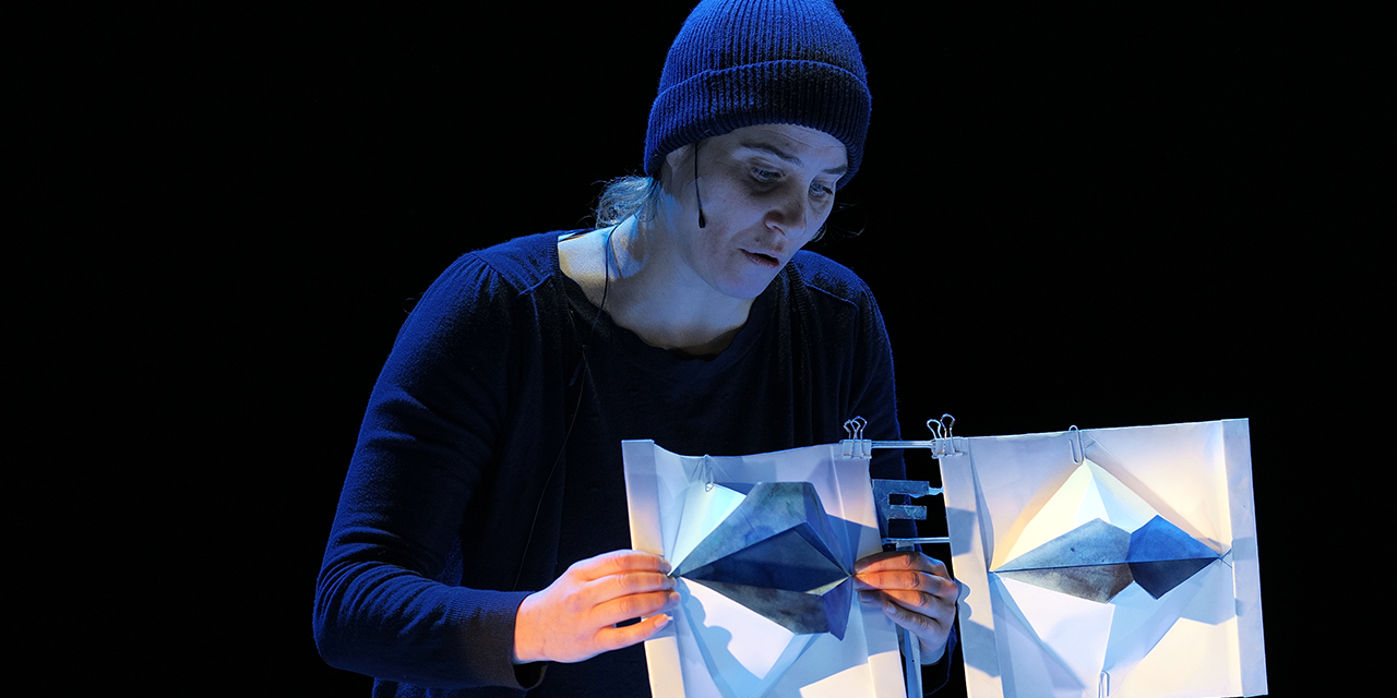 Une commédienne manipule des marionnettes en papier