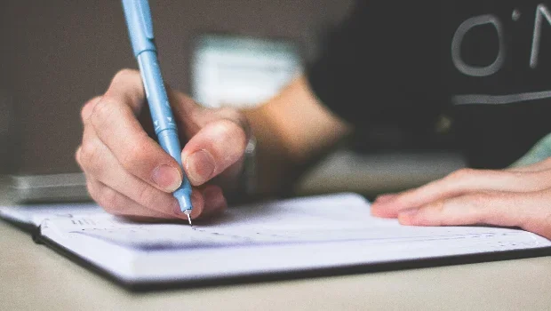 Une personne avec un stylo dans la main