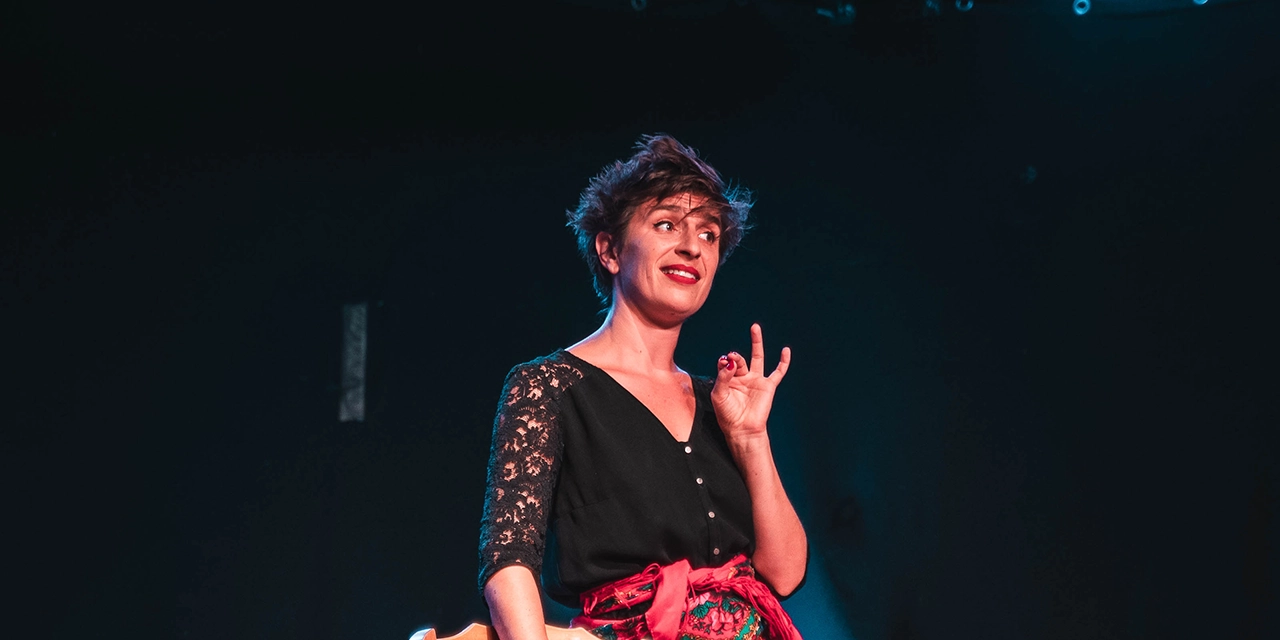 La comédienne se tient debout sur scène 