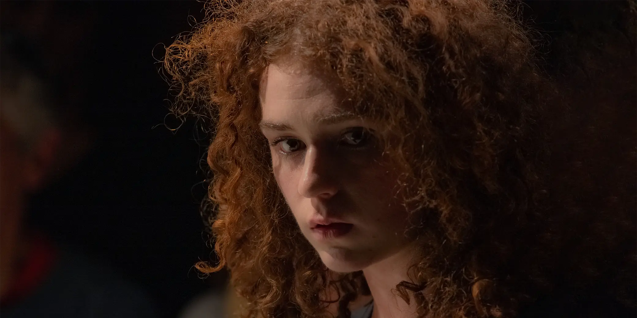 Portrait de la comédienne, une jeune femme rousse au cheveux frisés