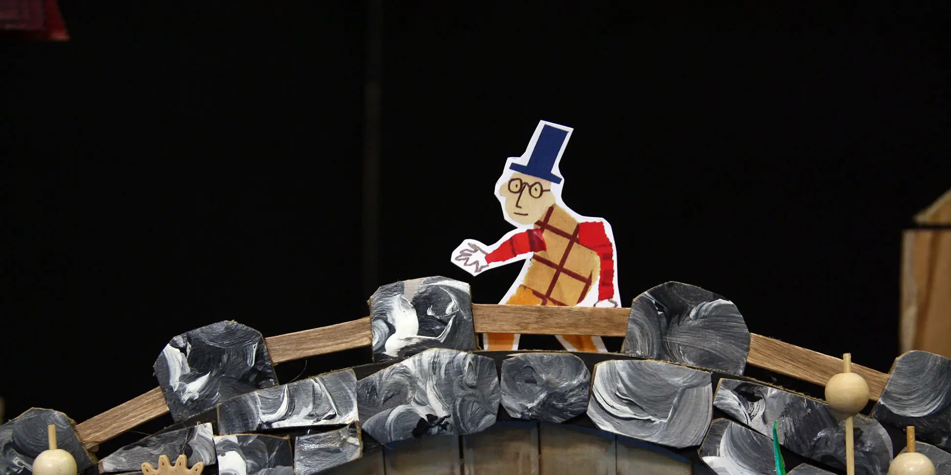 Le personnage en papier monsieur Flaubert traverse un pont en carton