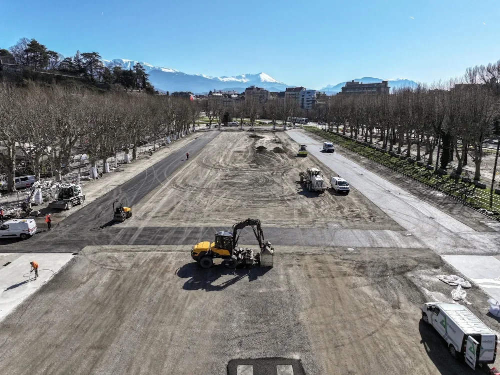 Un bulldozer et d'autres engins de chantier travaillent à l'installation du nouveau sol de l'esplanade.