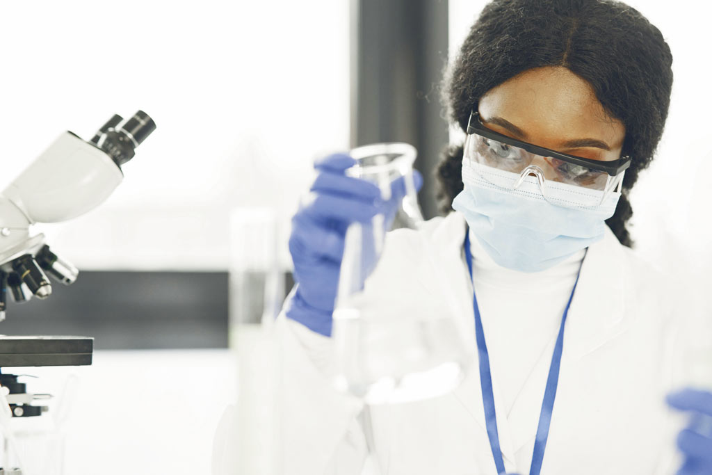 Une femme manipule des liquides dans un laboratoire.