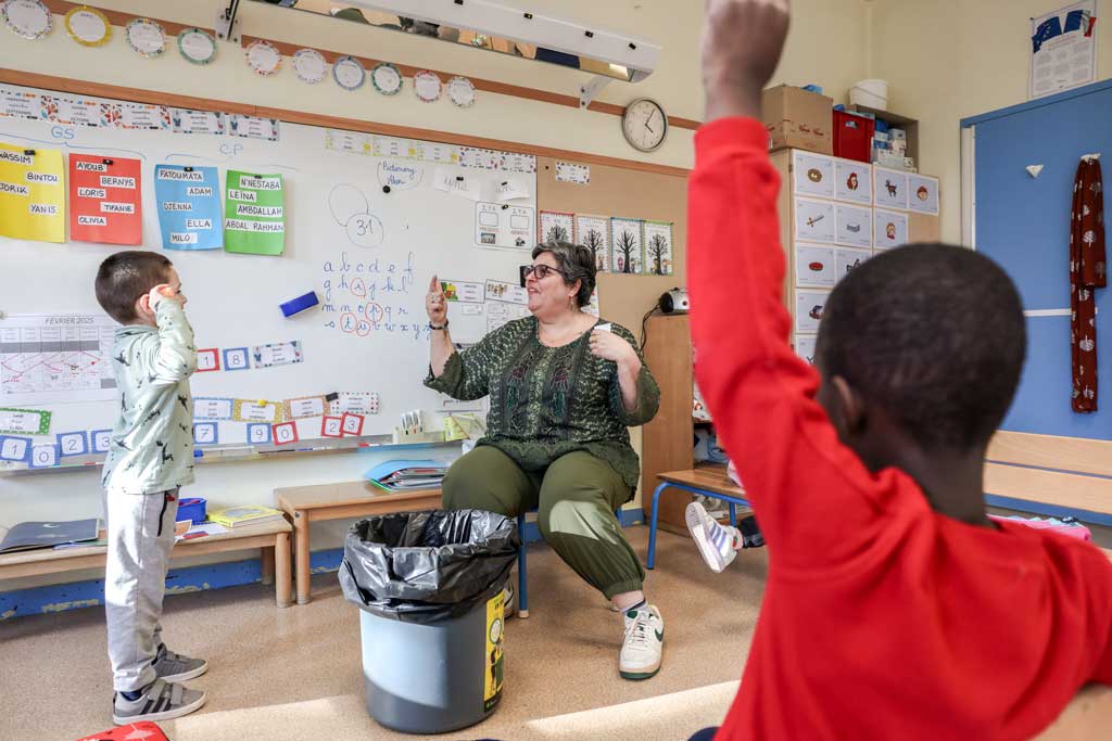 Céline échange dans une classe avec des enfants.