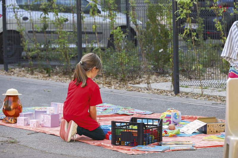 Une petite fille joue à des jeux dans la cour.