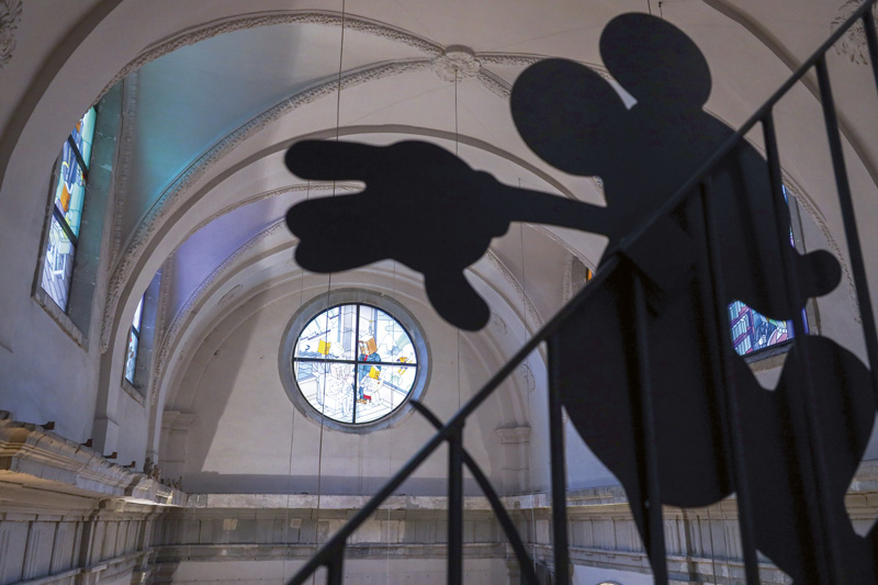 Mickey en ombres devance un vitrail représentant les métiers de l'imprimerie.