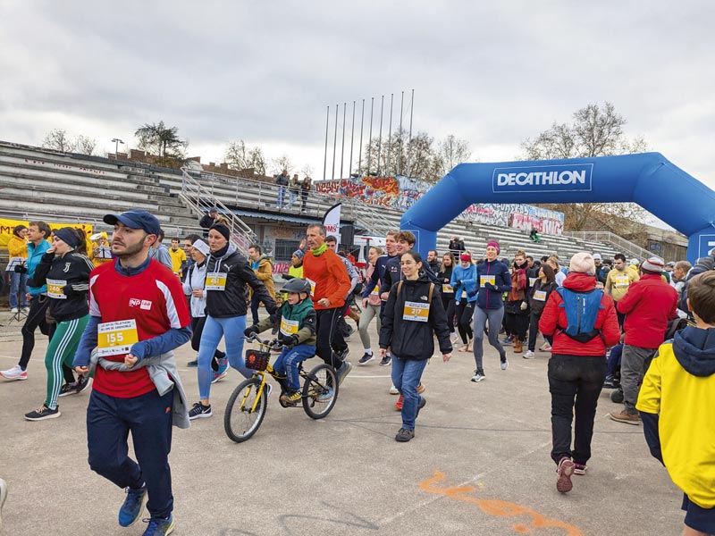 Un grand groupe de personnes est au départ de la course sur l'anneau de vitesse.