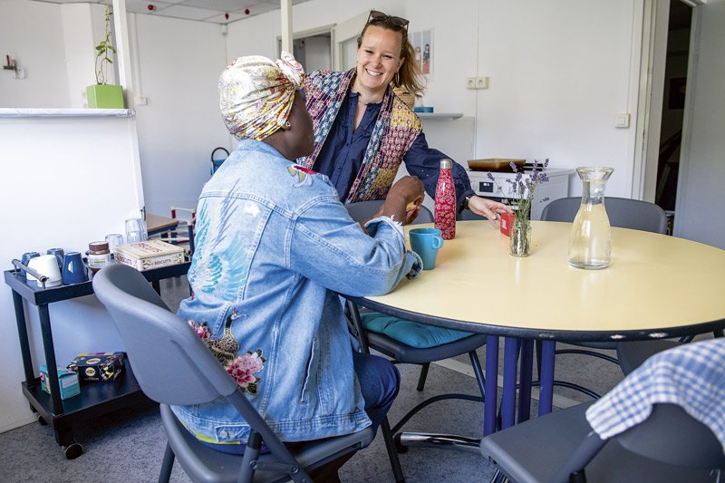 Deux femmes discutent autour d'une table.