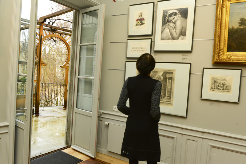 Une personne regarde des tableaux.