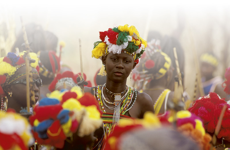 Une femme portant des habits traditionnels se détache au milieu d'une foule.
