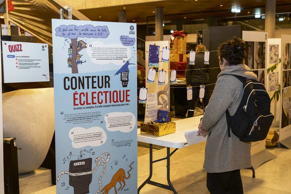 Une femme découvre l'exposition sur la précarité énergétique à l'Hôtel de Ville