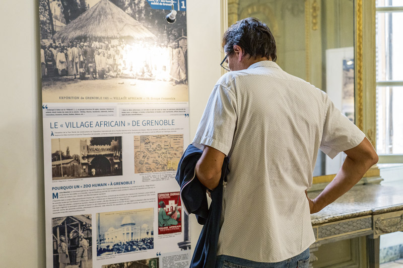 Un homme lit un panneau de l'exposition.