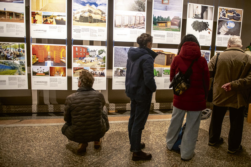 Des personnes regardent l'exposition. 