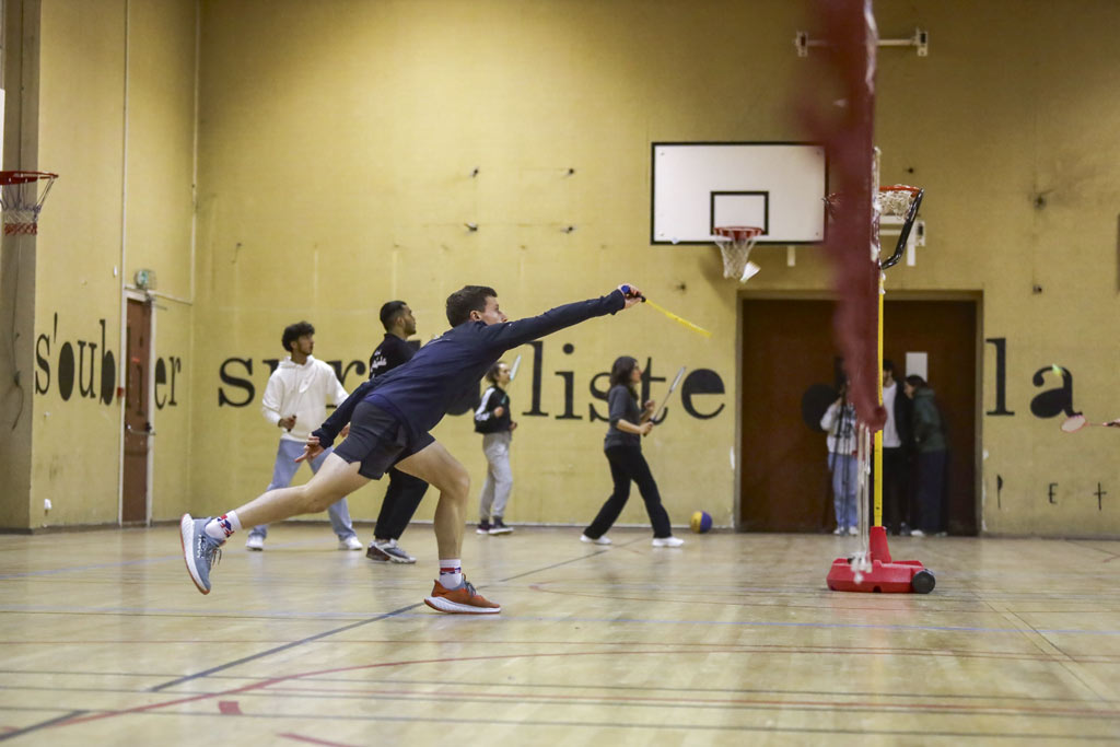 Des personnes jouent au badminton dans un gymnase.