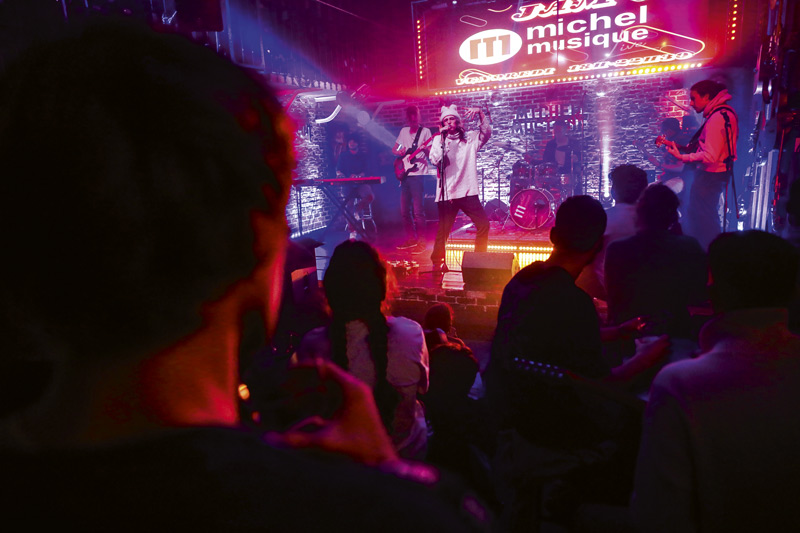 Des spectateurs écoutent des musiciens jouer sur scène.