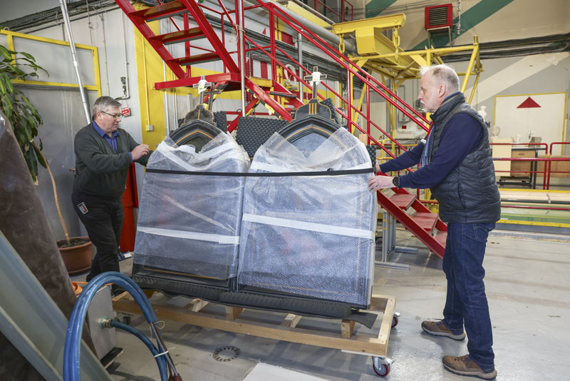 Deux hommes déplacent minutieusement deux oeuvres de l'art sacré.