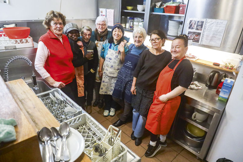 Photo de huit bénévoles dans la cuisine du restaurant.