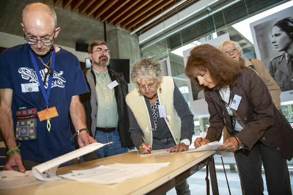 Des personnes âgées remplissent des papiers.