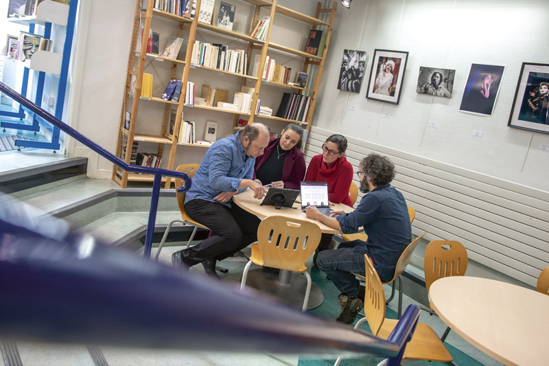 Quatre personnes discutent autour d'une table. 