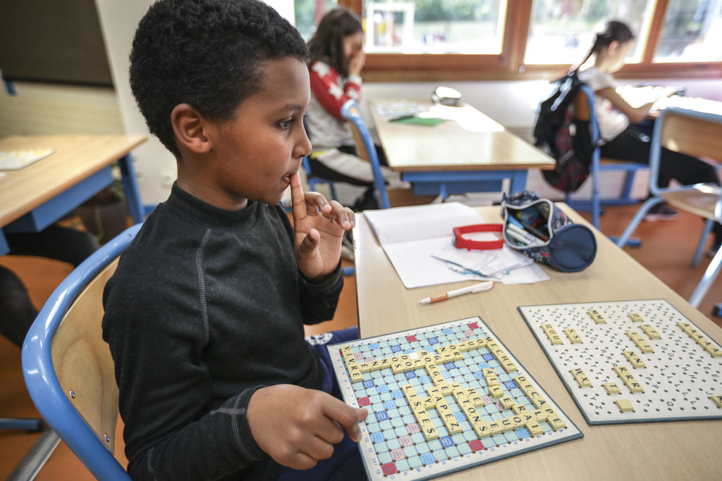 Un enfant joue au scrabble.