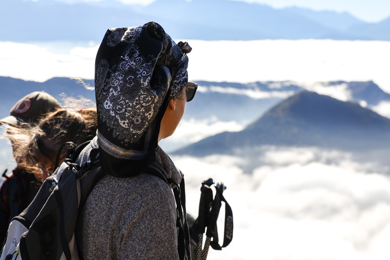 Une femme regarde le paysage depuis un sommet.