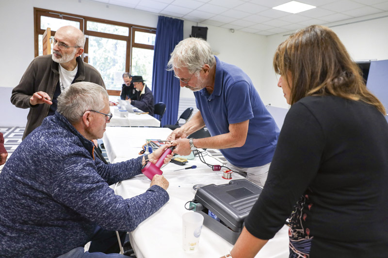 Quatre personnes sont en train de réfléchir pour réparer un sèche-cheveux.