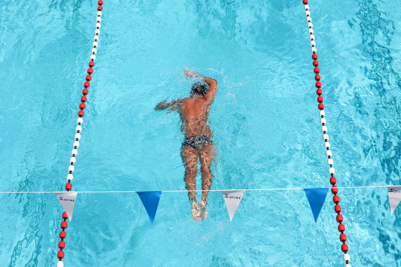 Une personne réalise des longueurs dans une piscine.