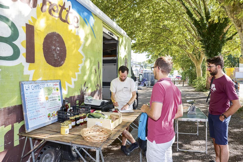 Des clients viennent chercher leurs légumes dans une camionette.