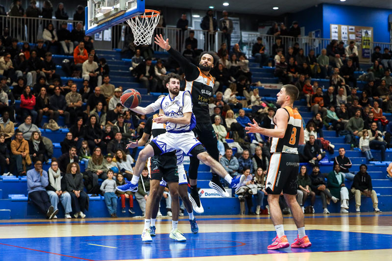 Les joueurs sont en plein match au pied du panier.