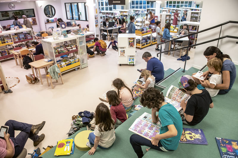 Des enfants lisent des BD dans la bibliothèque.