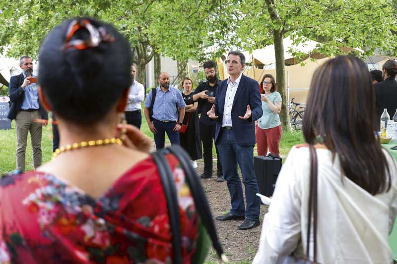 Eric Piolle s'exprime au milieu d'autres personnes dans un parc.