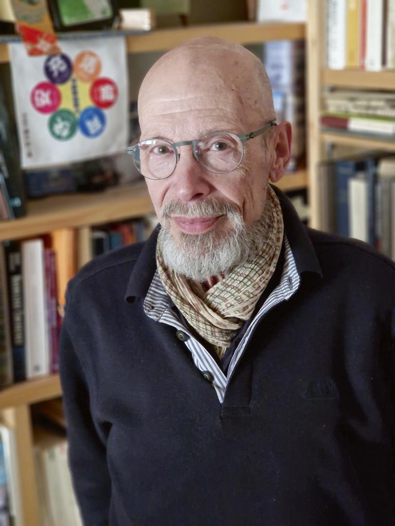 Marc Humbert pose dans une bibliothèque.