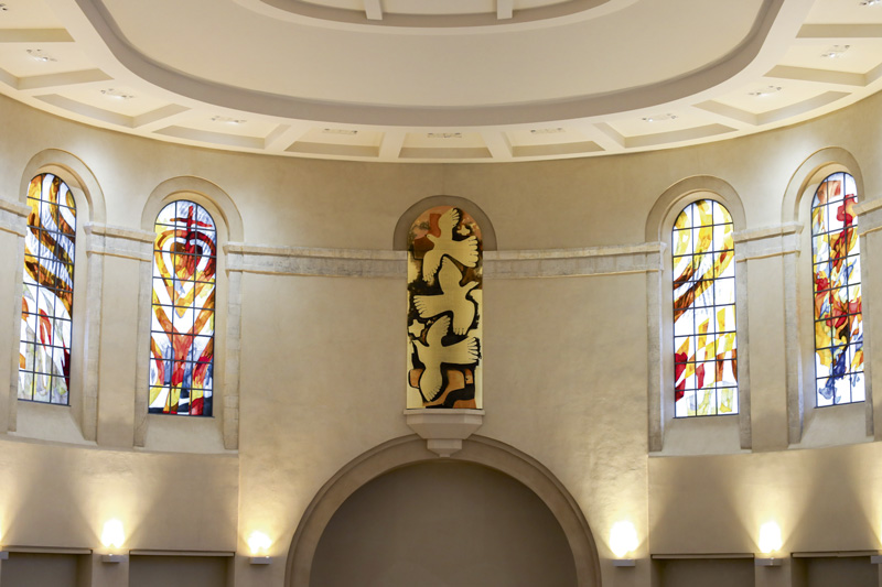 Des grands vitraux sont alignés dans la basilique.