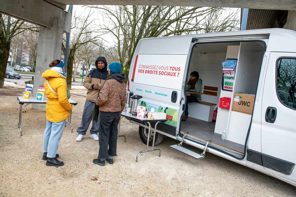 Des personnes discutent devant la Caravane des droits.