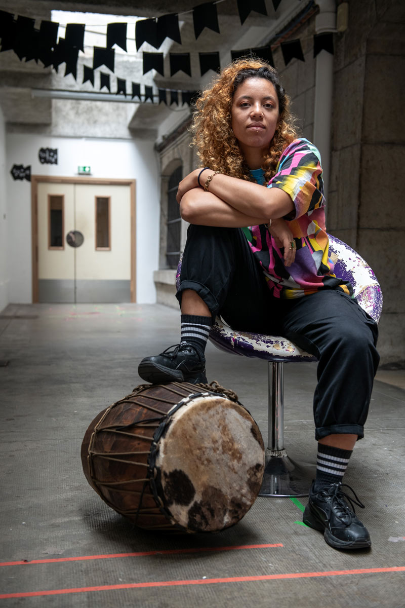 Portrait de Lwanbé accompagnée de son instrument.