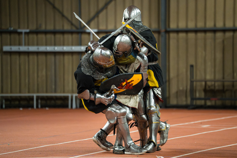 Trois combattants sont en mêlée.