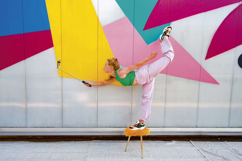 Une femme se filme avec une perche à selfie.