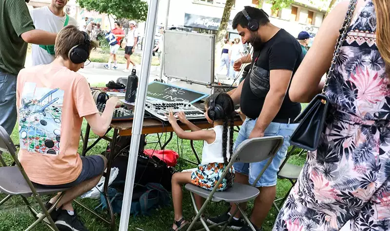 Une petite fille crée du son grâce à des machines électroniques.