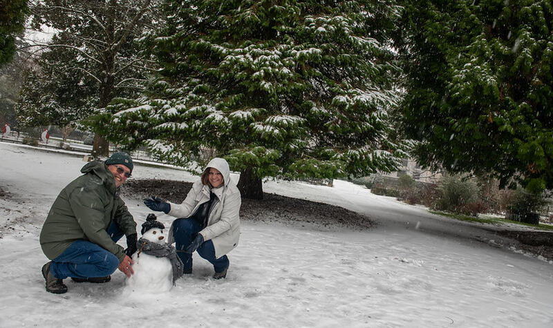 Un homme et une femme ont construit un bonhomme de neige.