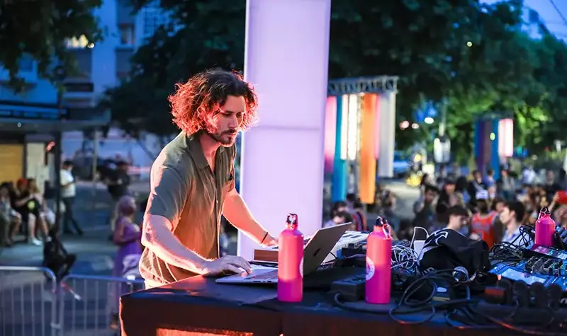 Un DJ joue avec ses platines et son clavier. 